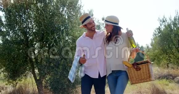 浪漫的情侣在橄榄农场用柳条篮子散步视频的预览图