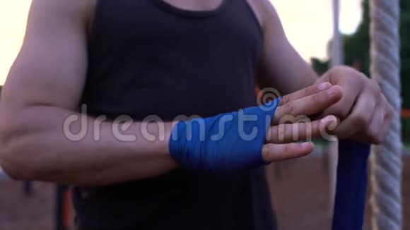 强壮的跆拳道男子穿上拳包并得到他的手掌拳头视频的预览图