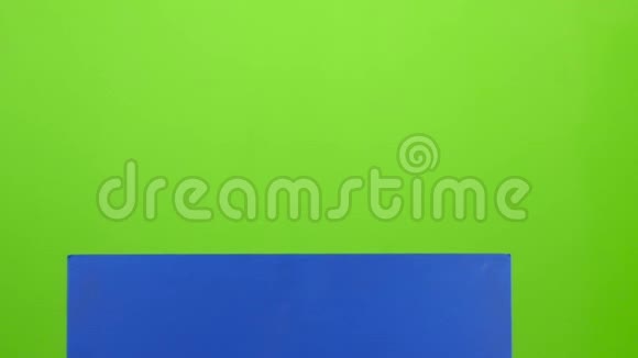 男孩从一张蓝色的海报后面出现他的牙齿摇动他的头和曲线的脸然后又隐藏起来绿色视频的预览图