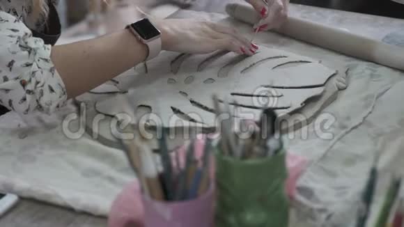 一个女人正在把图案涂在粘土上视频的预览图