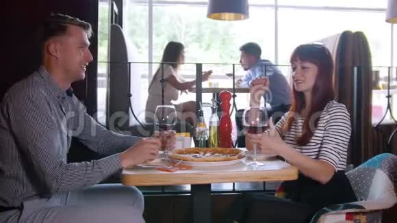 年轻夫妇坐在餐馆里聊天喝酒视频的预览图