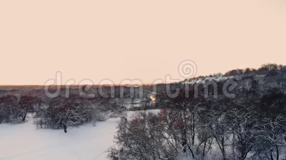 下雪了冬季仙境下雪了日落黄昏的阳光森林树木森林大自然慢动作冬季视频的预览图