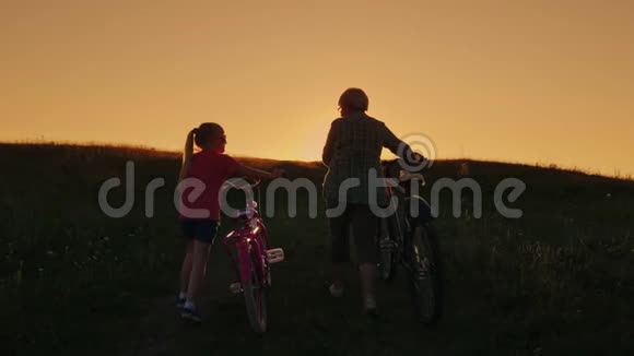 活跃的老年人一位带着孙女的老妇人正在爬山骑自行车后视图视频的预览图