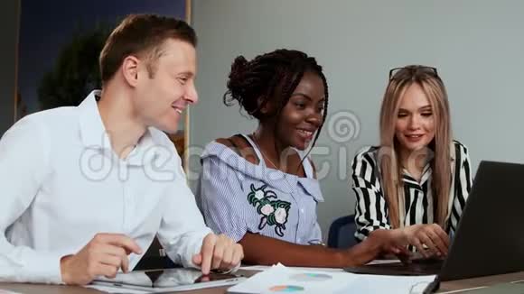 现代上班族坐在笔记本电脑前解决创造性任务创造新的商业产品多族裔群体视频的预览图