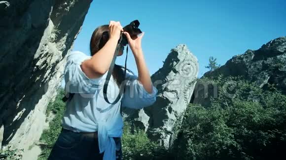 年轻女子背着背包在大峡谷拍照视频的预览图