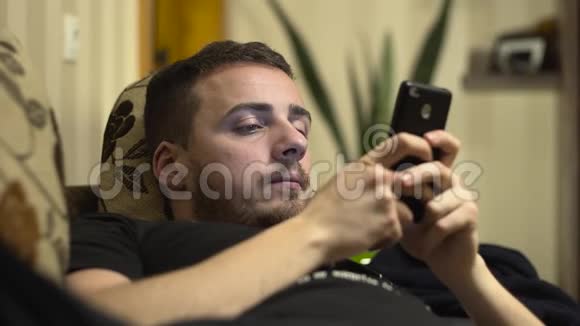 中型男子在床上用手机写短信视频的预览图