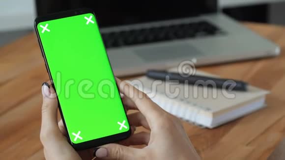 手拿绿色屏幕显示的手机视频的预览图