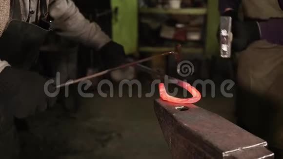 两个铁匠正在锻造铁马蹄铁在一个锻造特写视频的预览图