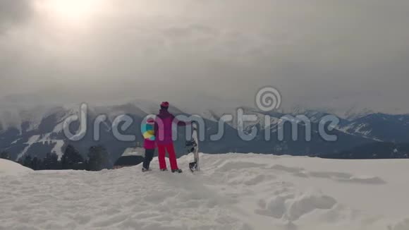 幸福的家庭在山上享受寒假家庭滑雪度假人们观察山景视频的预览图