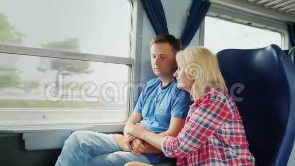 一对年轻的已婚夫妇正坐火车旅行他们一起看着窗外视频的预览图