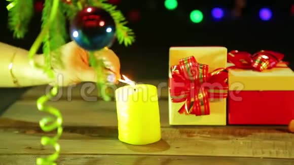 女性手在圣诞礼物旁边的桌子上点燃蜡烛视频的预览图