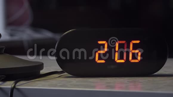 黑色塑料电子数字时钟在桌子上以橙色表示时间视频的预览图
