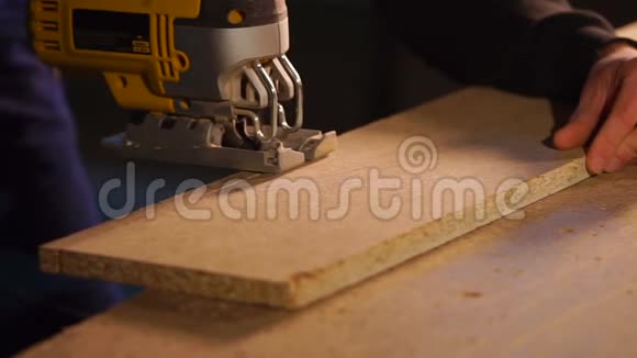木工正在锯掉一块刨花板的细节以便生产橱柜家具视频的预览图