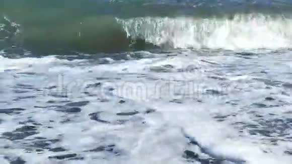 海泡沫击打岸上的特写希腊圣托里尼岛帕里萨海滩黑色火山沙视频的预览图