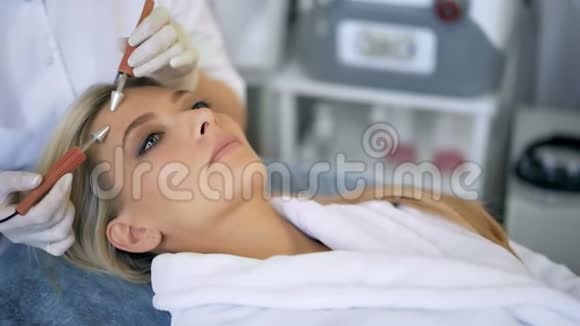 在碧蒂沙龙接受治疗师面部微电流治疗的美女特写视频的预览图