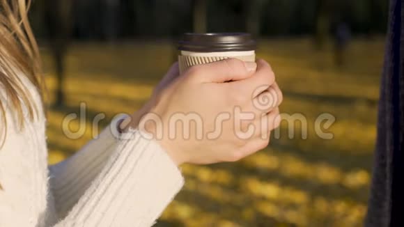 情侣们用一杯热饮料温暖冻僵的手秋日视频的预览图