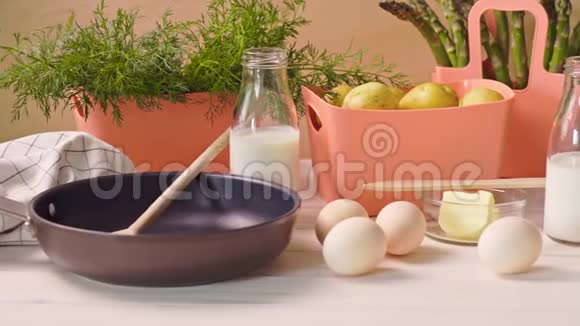 木制桌子上放有鸡蛋牛奶和煎锅的春菜视频的预览图