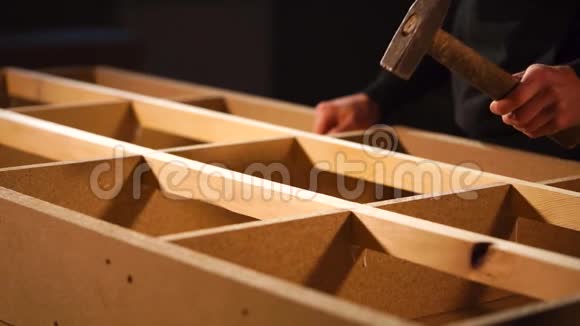 木匠用建筑锤敲击沙发框架的钢坯视频的预览图