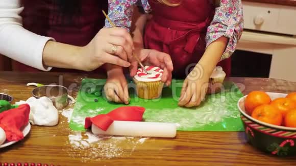母亲和女儿用糖泥装饰圣诞蛋糕视频的预览图