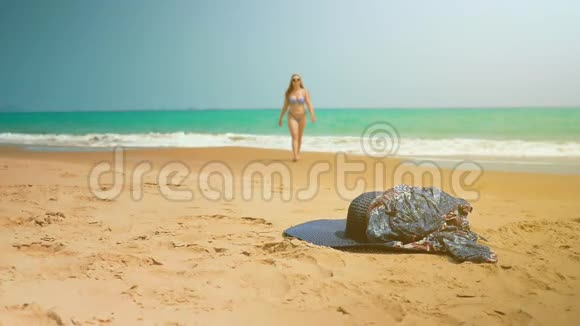 小女孩从海里出来从沙子里举起衣服中弹斯隆运动视频的预览图