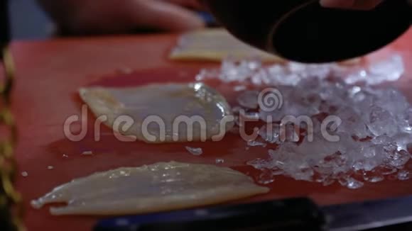 厨师把碎冰放在新鲜的生鱿鱼上视频的预览图