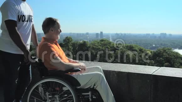 坐在轮椅上的人欣赏着城市的景色视频的预览图