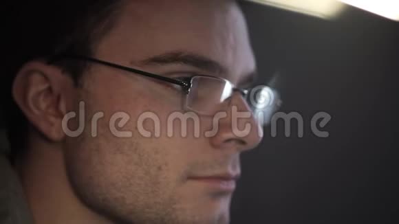 戴眼镜的年轻兴奋男子在电脑上工作的肖像和鬼脸视频的预览图
