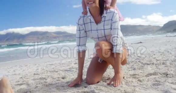 妈妈在海滩上给女儿搭顺风车视频的预览图