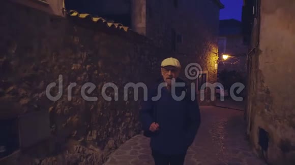 一位老人晚上走在瓦尔德摩萨村的中世纪街道上视频的预览图