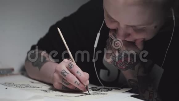 希普斯特纹身艺术家朋克女子在灯光下在书桌上素描视频的预览图