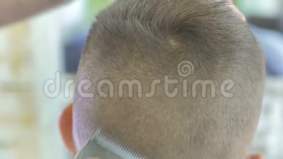 理发师用理发器剃一个小男孩的头视频的预览图