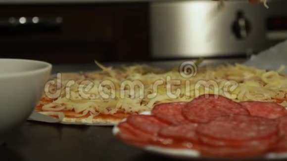 厨师在新鲜比萨饼面团上撒奶酪视频的预览图