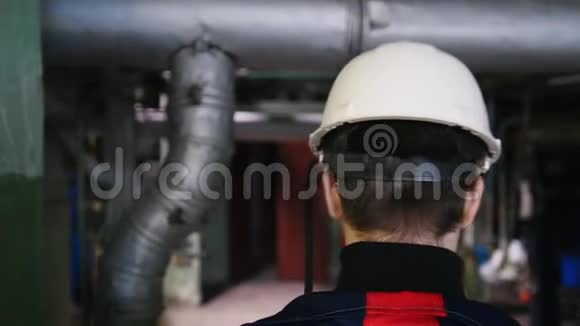 一个戴着头盔的男工程师在制造厂行走视频的预览图