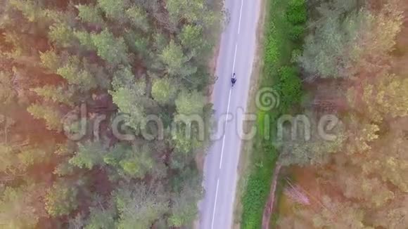 一辆骑着一条狭长道路的摩托车的俯视图4K视频的预览图