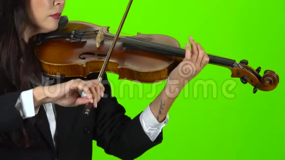女孩用手指弹奏小提琴的琴弦快关门绿色屏幕视频的预览图