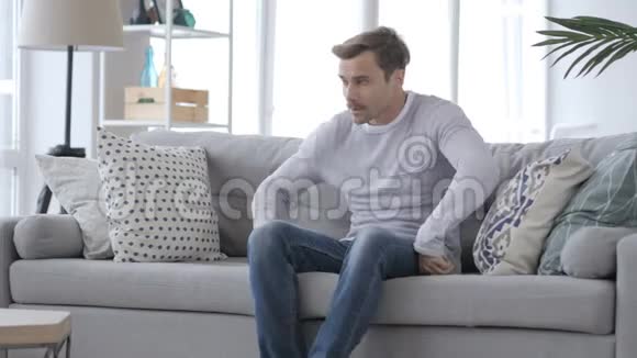 成年人坐在沙发上离开房间视频的预览图