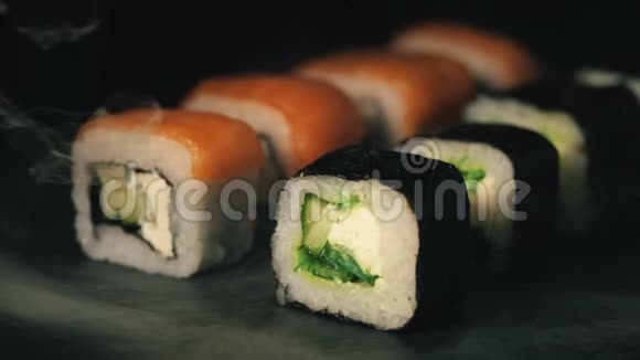 烟云中的两排寿司石板上的卷食物背景日本料理视频的预览图