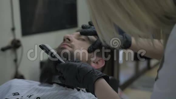 女理发师用危险的剃刀刮胡子视频的预览图