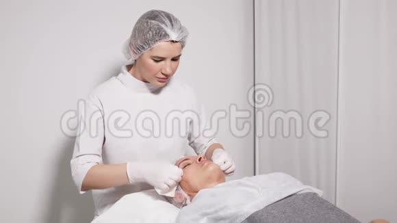 医生美容师给躺在特殊桌子上的病人卸妆视频的预览图