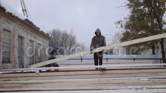 冬天海弗在锯木厂的院子里搬运木板视频的预览图