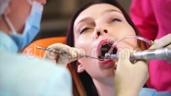 牙科诊所的医生用水和镜子冲洗病人牙齿视频的预览图