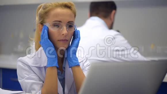 疲劳妇女在实验室头痛时按摩太阳穴视频的预览图