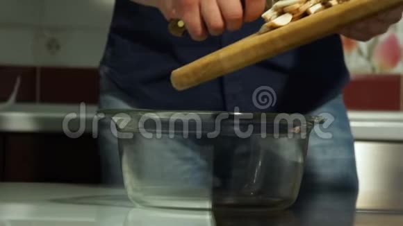 男厨师把切碎的蘑菇倒入碗中视频的预览图