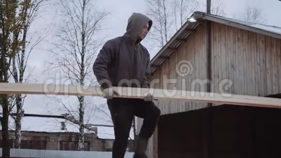 冬季白天在锯木厂院子里搬运木板的工人视频的预览图