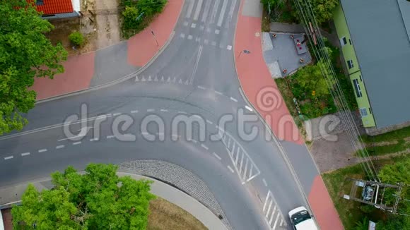 两辆车穿过城市弯曲的十字路口鸟瞰视频的预览图