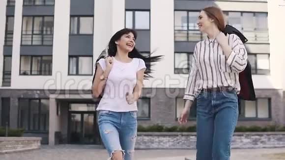 最好的朋友在街上走来走去时笑着和愚弄女孩们在散步中享受美丽的天气慢慢慢慢视频的预览图