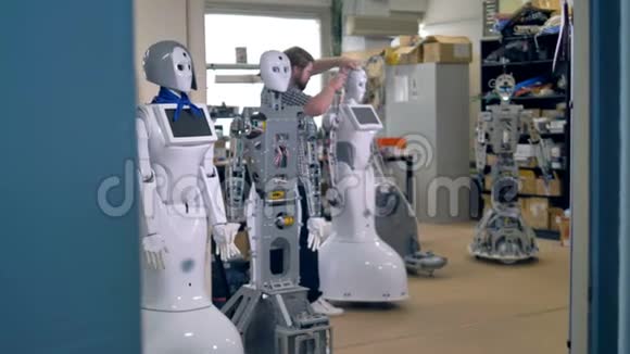 一排高大的机器人等待着忙碌的修理工开始修理它们4K视频的预览图
