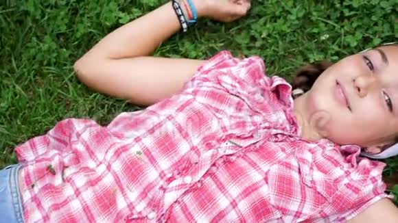 俯视图美丽的少女躺在草地上视频的预览图