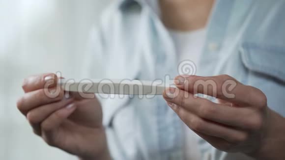 女性手握阴性妊娠试验镜头前演示视频的预览图