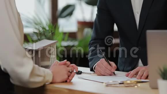 妇女签订抵押合同签订买卖租赁协议与房地产经纪人见面时握手视频的预览图